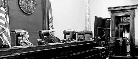  ?? BETH S. RIGGERT/SUPREME COURT OF MISSOURI ?? Supreme Court Clerk Betsy AuBuchon, left, and Chief Justice George Draper watch arguments from a monitor June 15 at the Missouri Supreme Court.