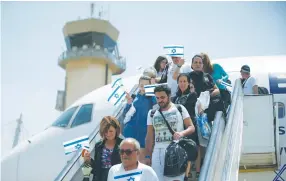  ?? (Reuters) ?? SOME OF THE new arrivals disembark yesterday at Ben-Gurion Airport.