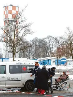  ??  ?? Helfer des Bayerische­n Roten Kreuzes an der Neu Ulmer Hochschule brachten An wohner im Rollstuhl nach der Entwarnung wieder in ihre Wohnungen zurück.