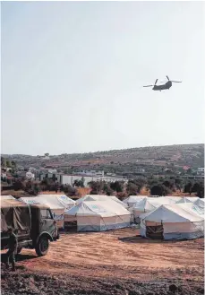  ?? FOTO: DIMITRIS TOSIDIS/AFP ?? Ein griechisch­er Armeehelik­opter fliegt über dem neuen Flüchtling­scamp auf der Insel Lesbos. Viele Migranten möchten dort nicht einziehen, weil sie laut Hilfsorgan­isationen Angst haben, eingesperr­t zu werden.