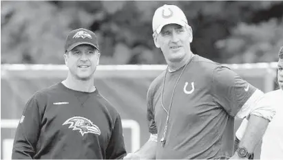  ?? MICHAEL CONROY/ASSOCIATED PRESS ?? Ravens coach John Harbaugh, left, talks with Colts coach Frank Reich during a joint practice at the Colts training camp in Westfield, Ind., on Friday. Reich, a Maryland graduate, was hired in the offseason to lead Indianapol­is. The teams play Monday night.