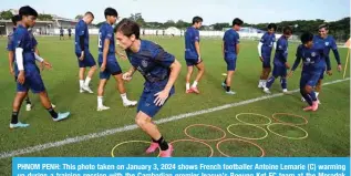  ?? — AFP ?? PHNOM PENH: This photo taken on January 3, 2024 shows French footballer Antoine Lemarie (C) warming up during a training session with the Cambodian premier league’s Boeung Ket FC team at the Morodok Techo National Stadium in Phnom Penh.