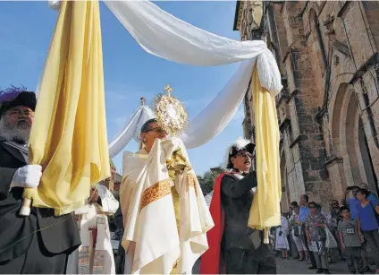  ?? Photos by Billy Calzada / San Antonio Express-News ?? Archbishop Gustavo García-Siller carries the monstrance with the Eucharist during the Feast of Corpus Christi procession.