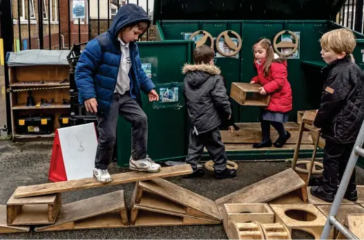  ??  ?? Risky business: Young pupils get to grips with planks and crates during their break time at the primary school in Essex