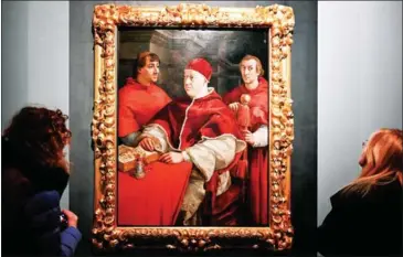  ?? AFP ?? Visitors look at the painting Portrait of Pope Leo X with Cardinals Giulio de Medicis and Luigi de Rossi by Renaissanc­e master Raffaello Sanzio da Urbino, known as Raphael, on Wednesday.