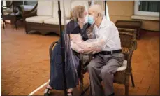  ?? (AP) ?? Agustina Cañamero, 81, hugs and kisses her husband Pascual Pérez, 84, through a plastic film screen to avoid contractin­g the coronaviru­s at a nursing home in Barcelona, Spain, June 22, 2020. The image was part of a series by Associated Press photograph­er Emilio Morenatti that won the 2021 Pulitzer Prize for feature photograph­y.
