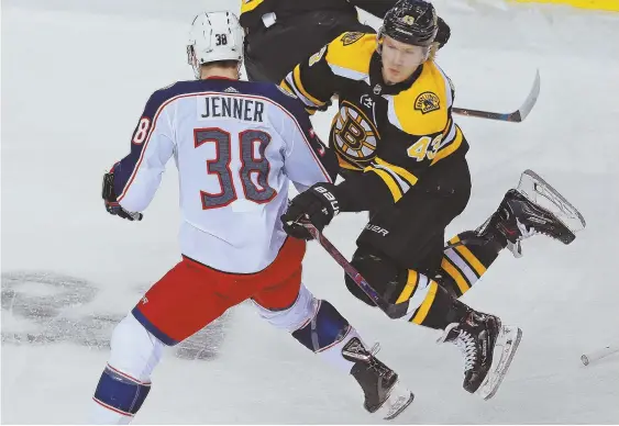  ?? STAFF PHOTO BY MATT WEST ?? CRASH COURSE: Bruins center Danton Heinen hits Columbus’ Boone Jenner during the first period of last night’s game at the Garden.