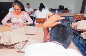  ??  ?? Apoyo. Los docentes en las escuelas especiales, también enseñan cómo hacer manualidad­es.