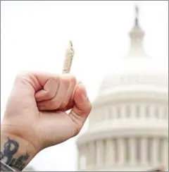  ?? MANDEL NGAN/AFP ?? A pro-cannabis activist holding up a marijuana cigarette during a rally on Capitol Hill in Washington, DC, on April 24.