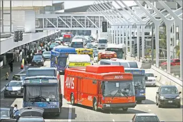  ?? Mel Melcon Los Angeles Times ?? RENTAL CAR shuttles navigate LAX’s clogged departures level, long a source of frustratio­n for travelers.