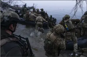  ?? (AP/Mstyslav Chernov) ?? Ukrainian servicemen board a boat on the shore of the Dnieper River at the front line near Kherson, Ukraine, on Oct. 15.