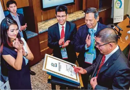  ??  ?? Energy, Green Technology and Water Minister Datuk Seri Dr Maximus Ongkili (right) signing the plaque for Honourable Mention for the Best Interpreta­tion of Theme after the Malaysia-Kazakhstan Energy Business Forum in Astana on Wednesday. With him are...