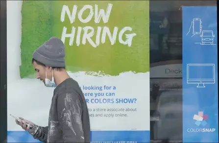  ?? TONY DEJAK — THE ASSOCIATED PRESS ?? A man walks past a “Now Hiring” sign on a window at a store Friday in Woodmere Village, Ohio. Fraud in the nation’s unemployme­nt systems is raising alarms even as President Joe Biden and Congress prepare to pour hundreds of billions more into expanded benefits for those left jobless by the pandemic.