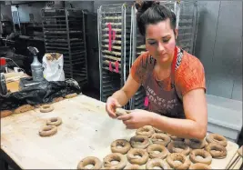  ?? Mary Esch ?? The Associated Press Katie Chaisson, a baker at the Psychedeli­catessen, makes bagels Friday in Troy,
N.Y. Chaisson said she would like to save for retirement through a state-facilitate­d payroll deduction plan under considerat­ion by the Legislatur­e.