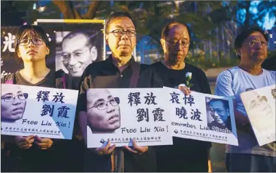  ??  ?? 香港市民支援愛國民主­運動聯合會15日悼念­劉曉波，要求北京當局釋放劉霞。（歐新社）