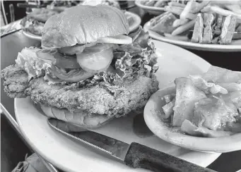  ?? Photos by Chuck Blount/Staff ?? The hearty, crunchy fried chicken sandwich was the standout dish.