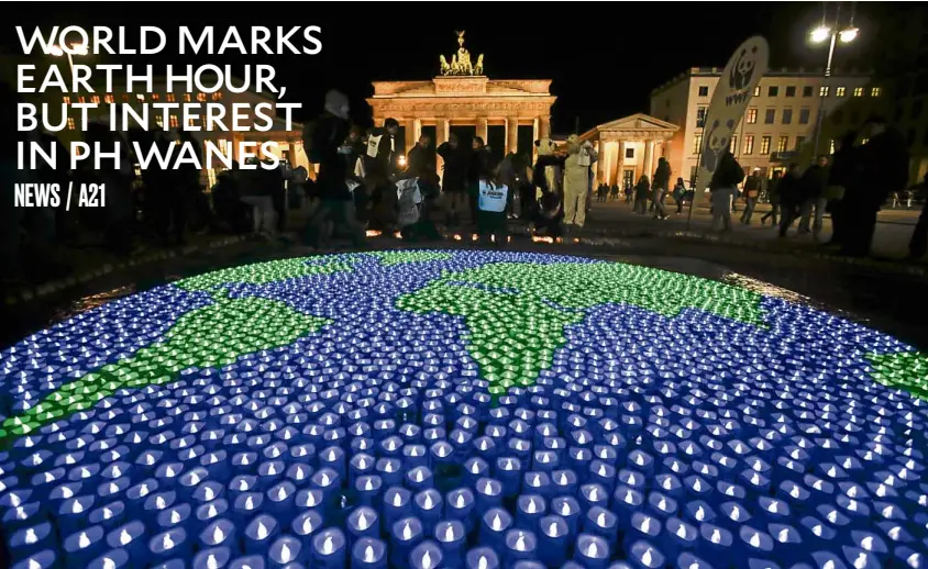  ?? —AP ?? LIGHTS OUT IN BERLIN Activists of World Wide Fund For Nature illuminate a globe with LED lights in front of the Brandenbur­g Gate in Berlin in observance of Earth Hour on Saturday.