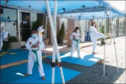  ?? BEA AHBECK/NEWS-SENTINEL ?? Owner Jamie Shelton shows a kick to student Perla Flores, 9, during class outside Robinson’s Taekwondo in Lodi on Wednesday.