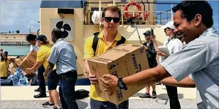  ?? MIAMI HERALD ?? Members of the Royal Caribbean GoTeam help unload supplies from the Empress of the Seas cruise ship at Freeport, Bahamas.