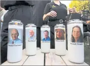  ?? JOSE LUIS MAGANA — THE ASSOCIATED PRESS ?? Photos of five journalist­s adorn candles during a vigil Friday night across the street from where they were slain in their newsroom in Annapolis, Md.