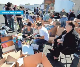  ?? JOE MAHONEY, RICHMOND TIMES-DISPATCH, VIA AP ?? Volunteers sort through donations for hurricane relief Sunday at Chino Stars Barbershop in Richmond, Va.