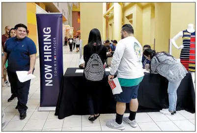  ?? AP/ALAN DIAZ ?? Job seekers check in at a booth during a recent job fair at the Dolphin Mall in Sweetwater, Fla. The U.S. Labor Department reported Tuesday that job openings were flat in September, after thousands of businesses closed after hurricanes Harvey and Irma.