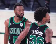  ?? Mark J. Terrill / Associated Press ?? The Boston Celtics’ Marcus Smart, right, is congratula­ted by Kemba Walker after scoring during an NBA Eastern Conference game against the Miami Heat on Thursday in Lake Buena Vista, Fla.