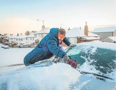  ??  ?? Solicitor Richard Gray, of Craigie, Perth, scrapes his car clear of ice as he battles to get to work.