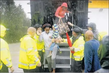  ?? David Goldman Associated Press ?? POLICE HELP residents evacuate their f looded neighborho­od as Tropical Depression Florence continues to pour Sunday. In Fayettevil­le, a military city of 200,000, nearly 1 in 5 residents lives below the poverty line.