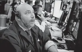  ?? RICHARD DREW/AP ?? A trader on the floor of the New York Stock Exchange reacts to higher opening stock numbers on Monday.