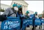  ?? ANDREW HARNIK - THE AP ?? Abortion rights advocates hold signs that read “Abortion is Essential” as they demonstrat­e in front of the U.S. Supreme Court, Wednesday, in Washington, as the court hears arguments in a case from Mississipp­i, where a 2018 law would ban abortions after 15 weeks of pregnancy, well before viability.