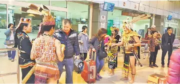  ??  ?? An STB photo handout showing passengers being greeted with a traditiona­l Sarawakian welcome upon their arrival at KIA.
