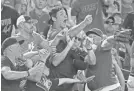  ?? DAVID KADLUBOWSK­I/AZCENTRAL SPORTS ?? Fans try to catch a foul ball during the sixth inning of Sunday afternoon’s game between the Diamondbac­ks and Phillies at Chase Field in Phoenix.