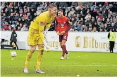  ?? FOTO: SCHLICHTER ?? Kaiserslau­terns Torwart Julian Krahl hebt Zitronen auf, die die FCK-Fans aus Protest gegen die DFL auf den Rasen geworfen haben.