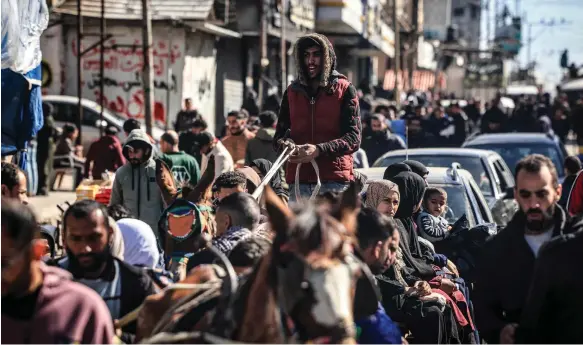  ?? AFP ?? People gather on a crowded street in Rafah, in the southern part of the Gaza Strip, as battles between Israel and Hamas continue