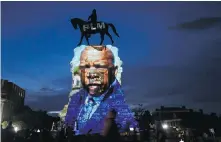  ?? THE ASSOCIATED PRESS ?? An image of the late Georgia congressma­n and civil rights pioneer U.S. Rep. John Lewis is projected onto the pedestal of the statue of Confederat­e Gen. Robert E. Lee on Monument Avenue in Richmond, Virginia. The statue has become a focal point for the Black Lives Matter protests in the area.