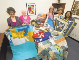  ?? JACQUELINE RAMSEYER/STAFF ?? Michelle Boyd, from left, Peggy Ludwico, Michelle Sullivan, Julianne Simone and Marie Barlahan show off quilts in July. The Bay Area Modern Quilt Guild and Santa Clara Valley Quilt Associatio­n members gave blankets to victims of the Twin Pines Manor...