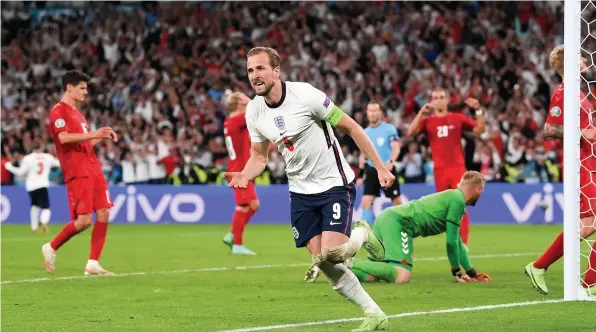  ??  ?? Harry Kane races away to celebrate after scoring the rebound from his penalty in last night’s Euro 2020 semi-final against Denmark at Wembley