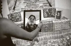  ?? Rodrigo Arangua / AFP / Getty Images ?? One of the rituals of el Día de los Muertos is the creation of an altar honoring a loved one. Here, a relative of Alma Delia Romero Sanchez, who died from COVID-19, prepares an altar in her honor in Mexico City. This year Mexicans are dedicating the traditiona­l altars to COVID-19 victims.