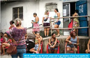  ?? — AFP ?? RIO DE JANEIRO: In this file photo, people wait to get donations of basic food supplies distribute­d by an NGO within the novel coronaviru­s (COVID-19) outbreak at the Cidade de Deus (City of God) favela in Rio de Janeiro.
