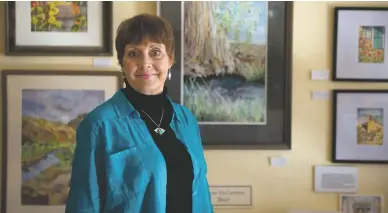  ??  ?? BOTTOM: ACCOMPLISH­ED ARTIST KAREN MCCURTAIN-BLAIR poses alongside her watercolor paintings on Jan. 31 at Las Comadres Gallery in Taos. Mccurtain-blair began her art studies at the University of Illinois, but as her daughter noted, ’She studied with incredibly talented artists wherever we were living.’