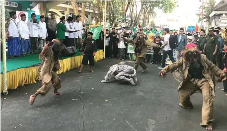  ?? GALIH WICAKSONO/JAWA POS ?? MENGHIBUR: Atraksi pencak macan mengawali pelepasan peserta Kirab Resolusi Jihad NU dan Pawai Santri Kreatif untuk memperinga­ti Hari Santri 2019 di alun-alun kemarin.