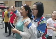  ?? GREG BAKER/AFP PHOTO PHOTOS: ?? Above: A student waves to her friends as she prepares to leave with her mother after she finished a college entrance exam at a school in Beijing. Some students are reportedly hiring people to pose as their parents to attend parent-teacher meetings....