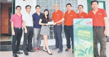  ??  ?? Christine (fourth left) receives her prize from Yong, in the presence of Nickky (second left) and other representa­tives from the organisers of Yeo’s Natural Beauty Contest 2017.