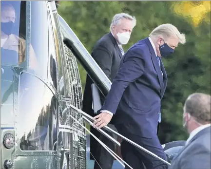  ?? JACQUELYN MARTIN — THE ASSOCIATED PRESS ?? President Donald Trump arrives at Walter Reed National Military Medical Center, in Bethesda, Md., Friday, on Marine One helicopter after he tested positive for COVID-19. White House chief of staff Mark Meadows is at second from left.