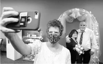  ?? DIRK SHADD/AP ?? Nan Klater, 63, takes a selfie portrait along with Lisa and Mike Wiard, of Tampa, after they said their vows Dec. 14 in Tampa. For over 25 years, Klater has officiated weddings across the Tampa Bay area.