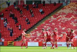  ??  ?? The Aberdeen players celebrate their goal in front of a socially-distanced crowd