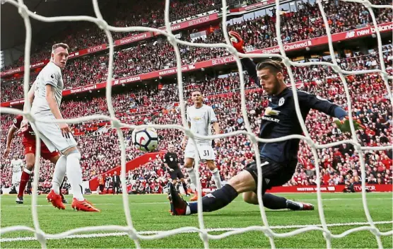  ?? — Reuters ?? No way through: Manchester United goalkeeper David De Gea making a save against Liverpool as Phil Jones (left) looks on in the English Premier League match at Anfield yesterday. The game ended 0- 0.