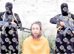  ??  ?? File photo courtesy of SITE Intelligen­ce Group shows Yasuda appealing for his release as two armed men stand behind him at an unknown location in Syria.