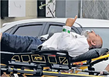  ??  ?? A man appears to pray as he is taken to an ambulance, above; a police officer leads a man away from the scene, left; a tweet by rugby star Sonny Bill Williams, right